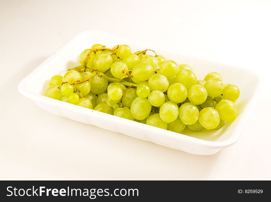 Grapes in tray on white ground