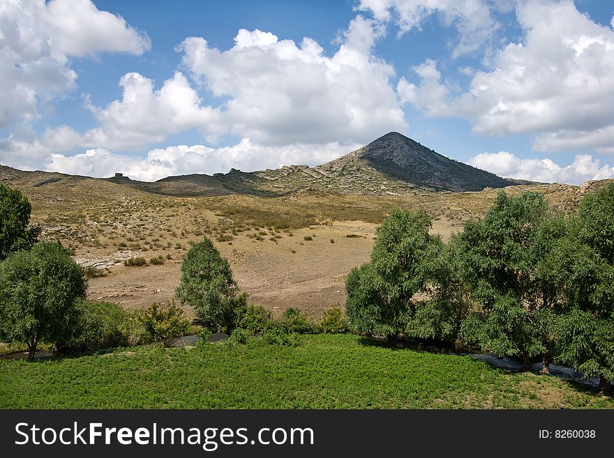 Pyramidal mountain with small river. Pyramidal mountain with small river