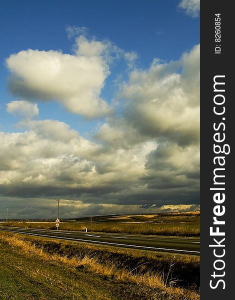 Image of a an empty road and blue sky and clouds. Image of a an empty road and blue sky and clouds