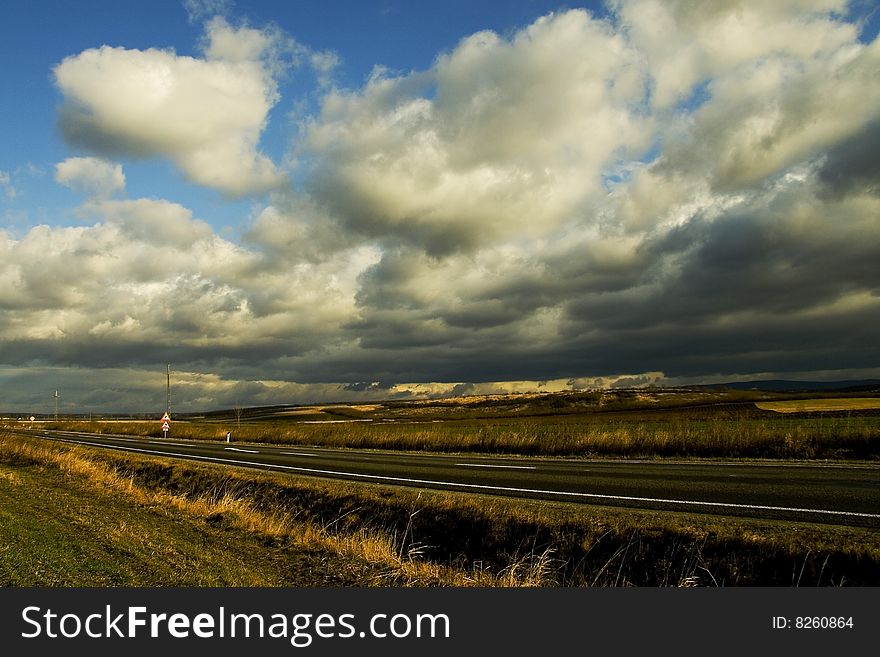 Image of a an empty road and blue sky and clouds. Image of a an empty road and blue sky and clouds