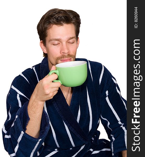 Young man in blue striped bathrobe enjoys his morning cup of tea isolated on white. Young man in blue striped bathrobe enjoys his morning cup of tea isolated on white