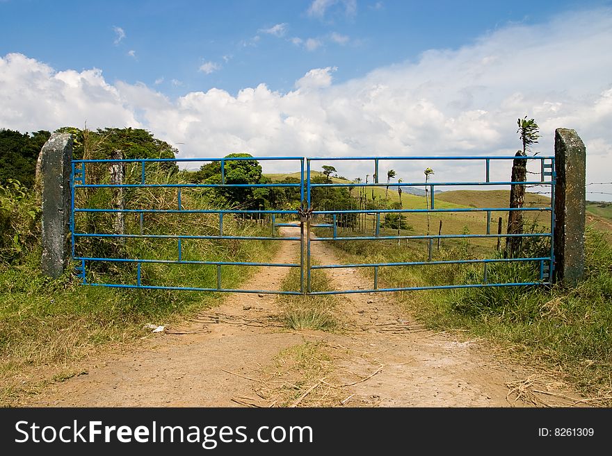 Closed blue metal gates on a country road in Costa RIca. Closed blue metal gates on a country road in Costa RIca