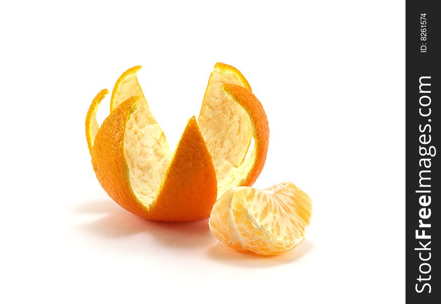 Tangerine peel cut out in the form of a crown and a tangerine segment isolated on a white background. Tangerine peel cut out in the form of a crown and a tangerine segment isolated on a white background