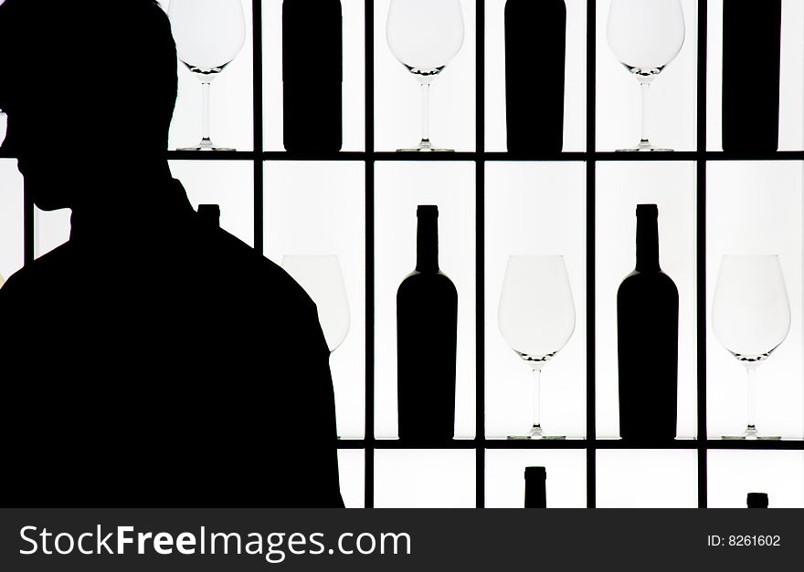 Silouette of a waiter against bottle and glasses