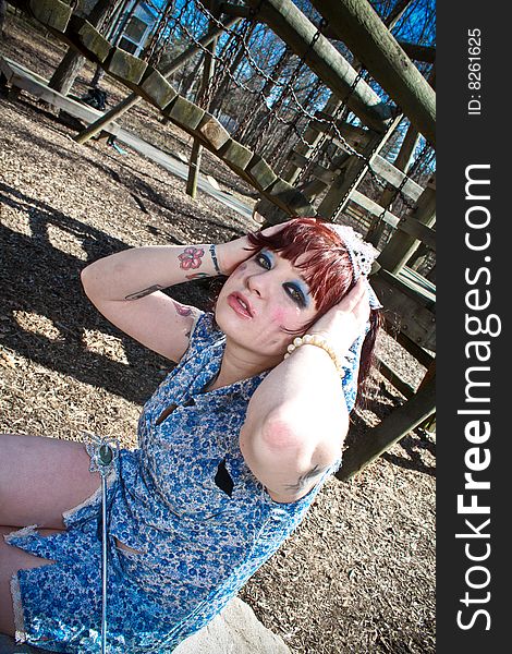 A girl sitting by a playground. A girl sitting by a playground