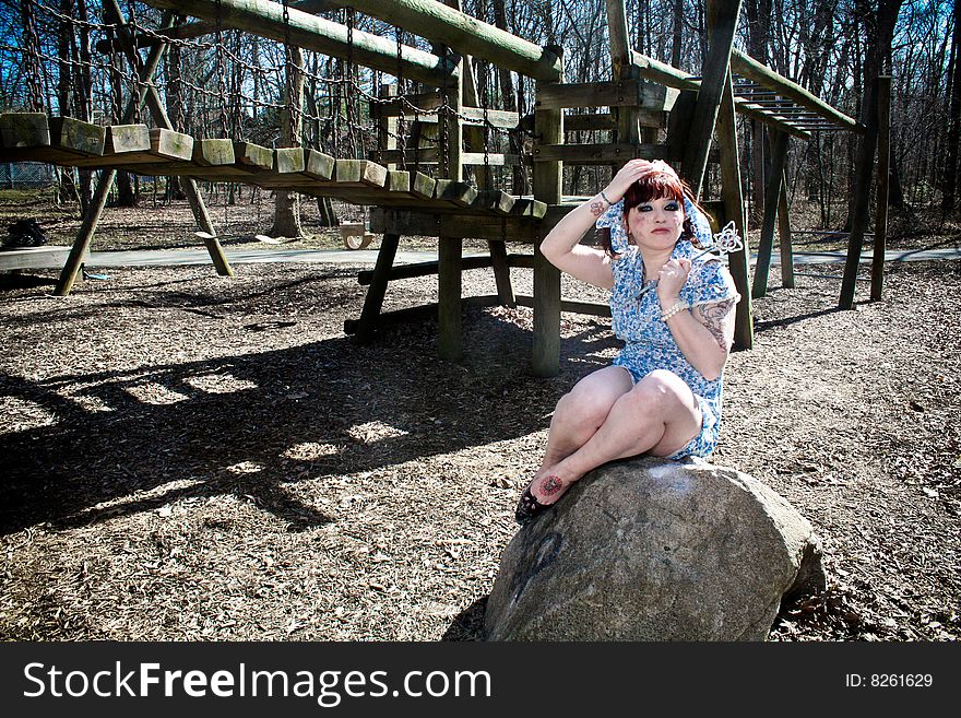 A girl sitting on a rock at a playground. A girl sitting on a rock at a playground