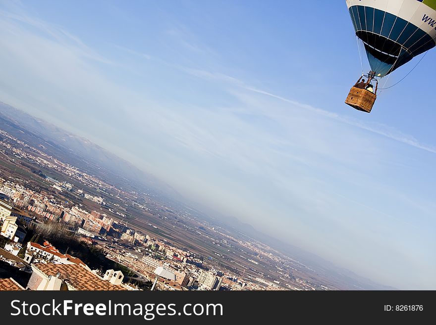 Unrecognizable people in balloon basket flying over city. Unrecognizable people in balloon basket flying over city