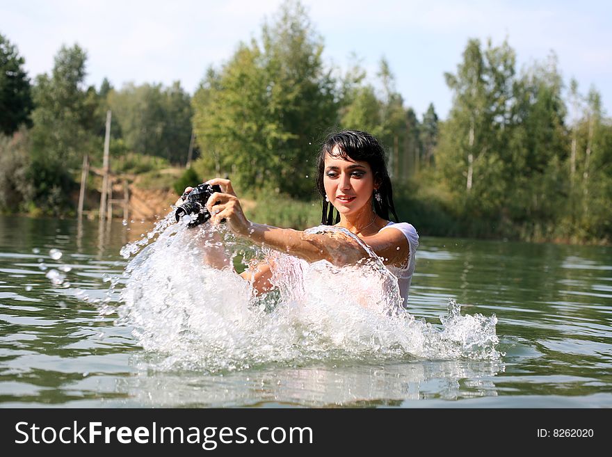 Lovely girl photographer in water in summertime