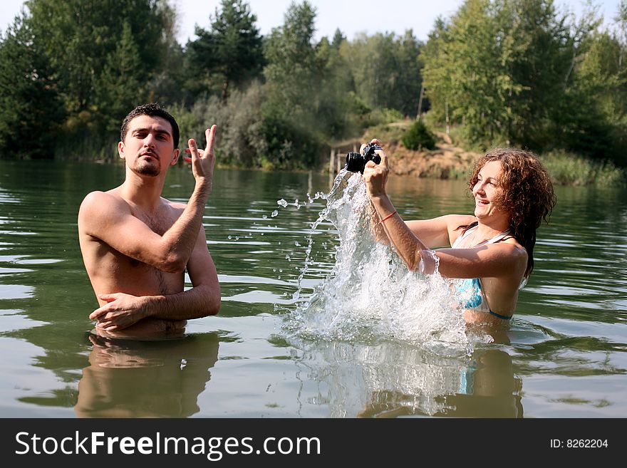 Girl shooting boy in water with waterproof camera. Girl shooting boy in water with waterproof camera