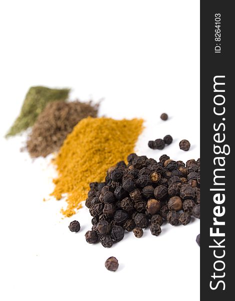 Haps of various ground spices on white background