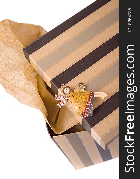 Closeup of opened gift box with craft paper inside and decorative angel