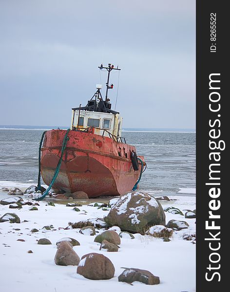 Photo of small shipwreck that has run ashore on rocks and ice after big storm. This photo is taken near Tiirimetsa in Saaremaa Estonia. Photo of small shipwreck that has run ashore on rocks and ice after big storm. This photo is taken near Tiirimetsa in Saaremaa Estonia.