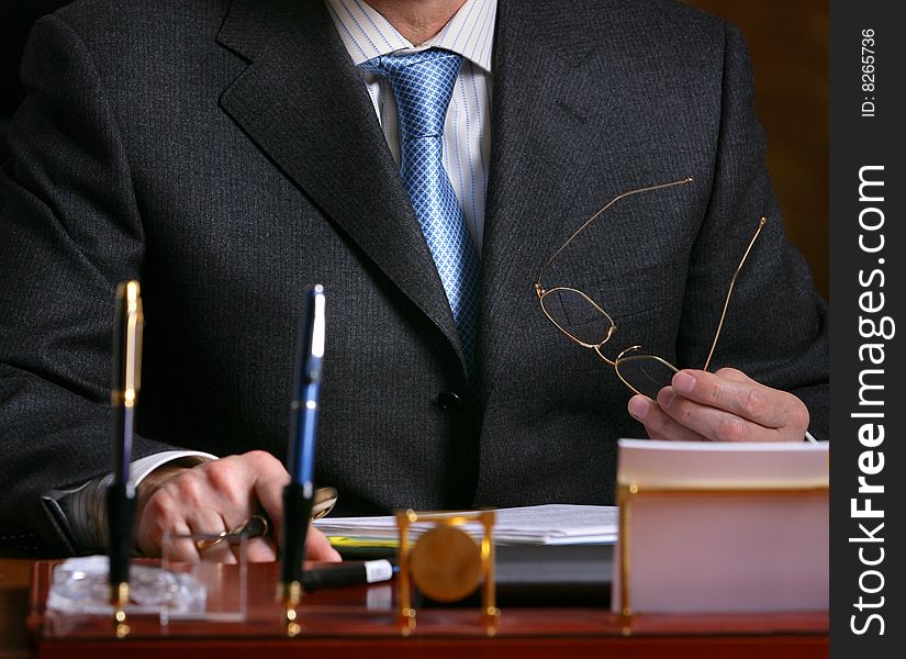Hand of a man in suit holding glasses. Hand of a man in suit holding glasses