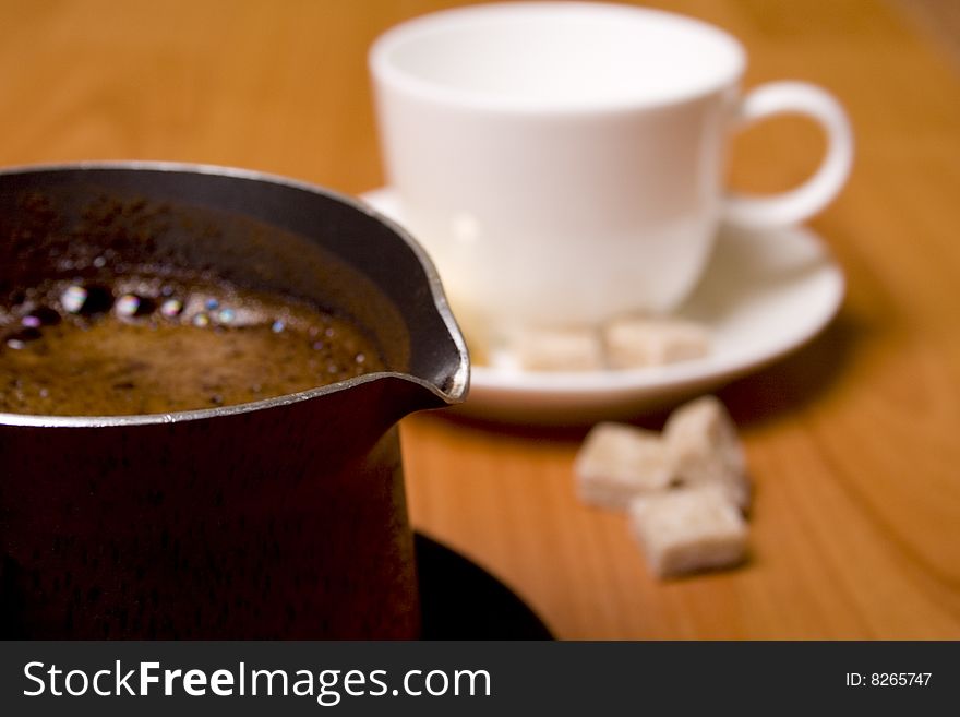 Coffee-maker, cup and sugar on wooden table