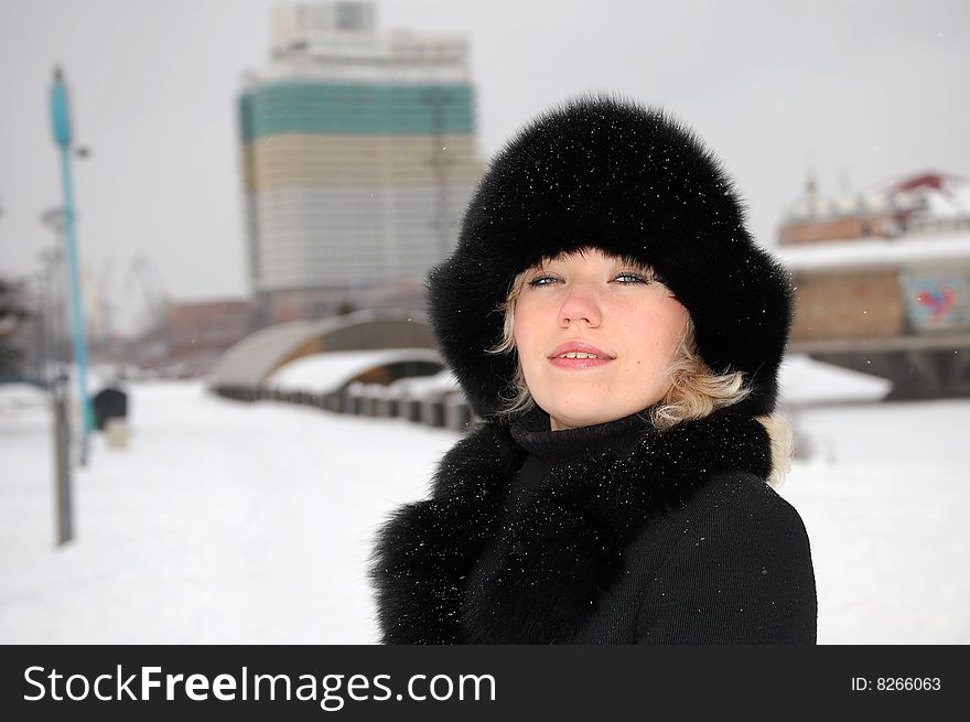 Portrait of the girl in winter near building