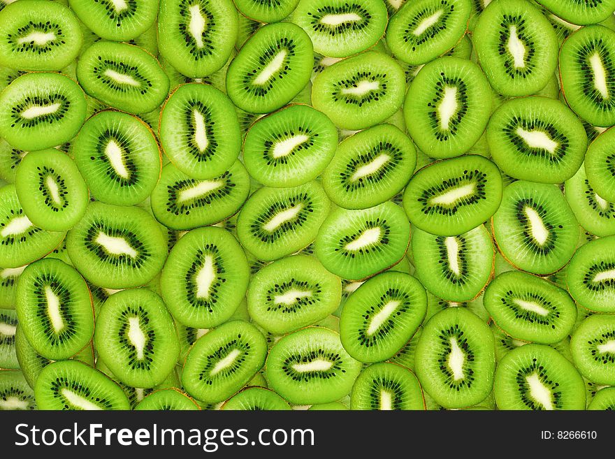 Sliced green kiwi fruit in the form of background. Sliced green kiwi fruit in the form of background