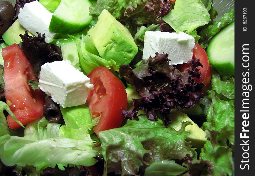 Macro photograph of fresh salad with avocado, fetta and tomatoes.