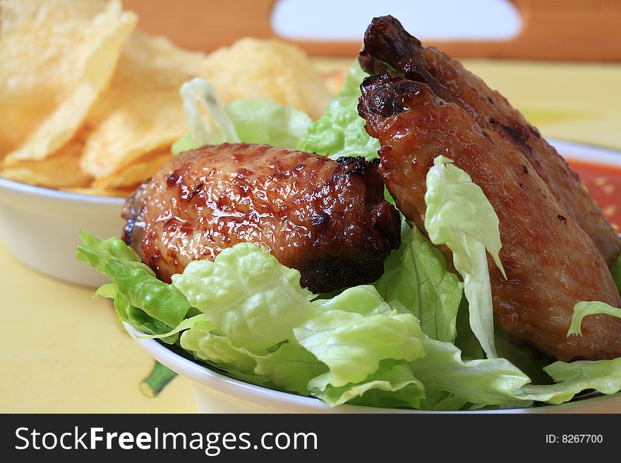 Grilled chicken wings with hot pepper sauce and salad