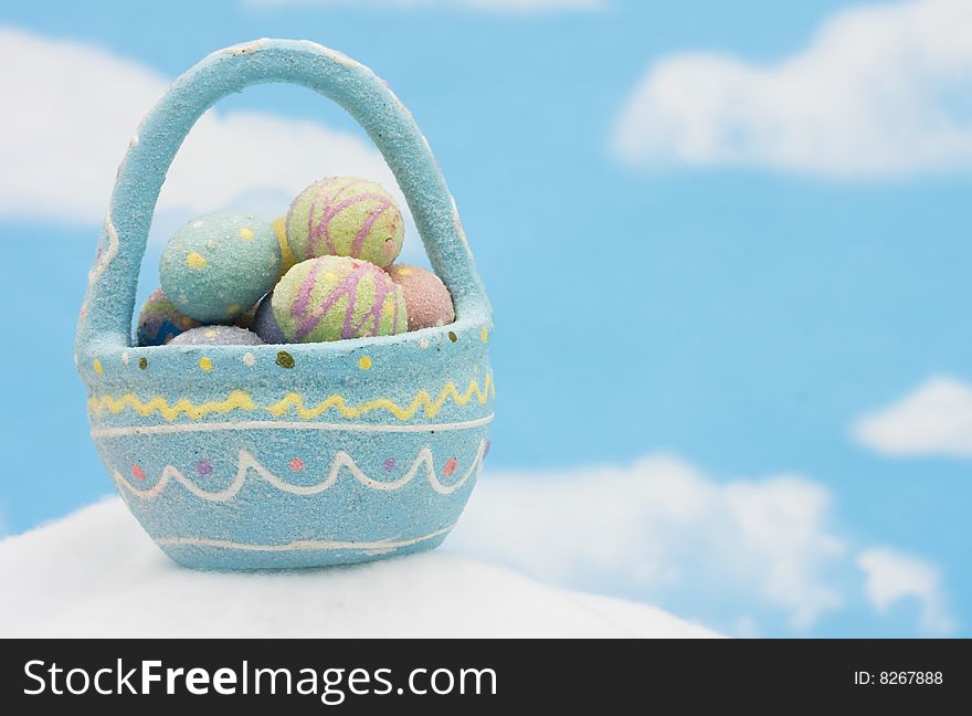 A basket of colourful Easter eggs on blue sky background, Easter