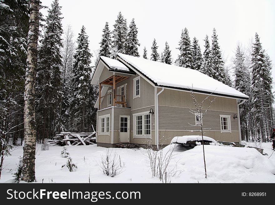 Wooden house in winter in a forest scenery, Finland