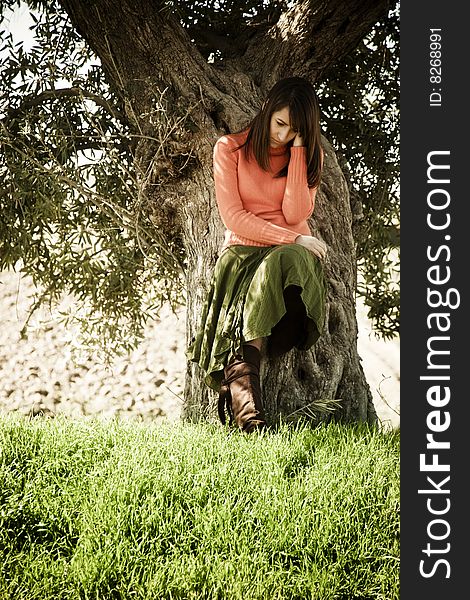 Young thoughtful woman on tree .