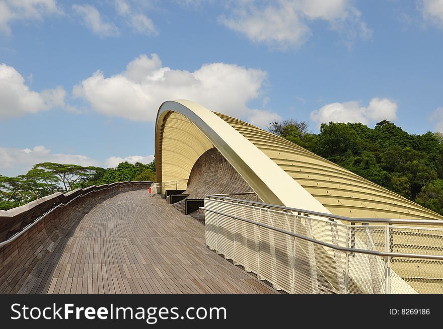 An unique design of a shelter and rest stop along a wooden walkway.