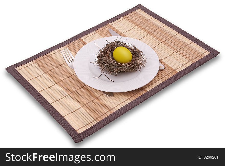 Gold egg in a nest served on a plate