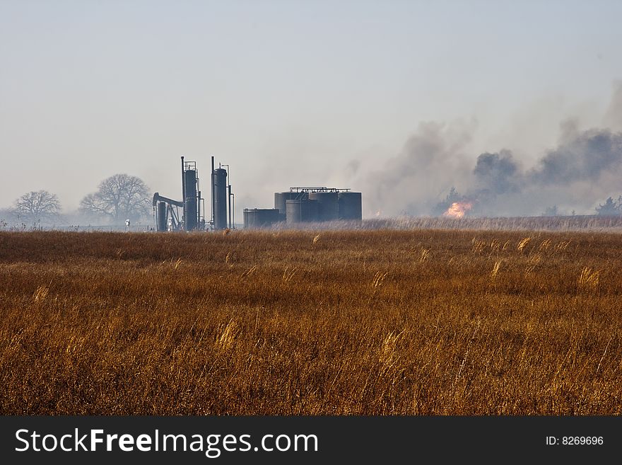 Grass fire near a some oil storage tanks and pump jack