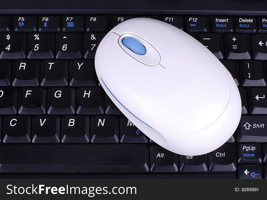 Black keyboard and white wireless mouse. Black keyboard and white wireless mouse