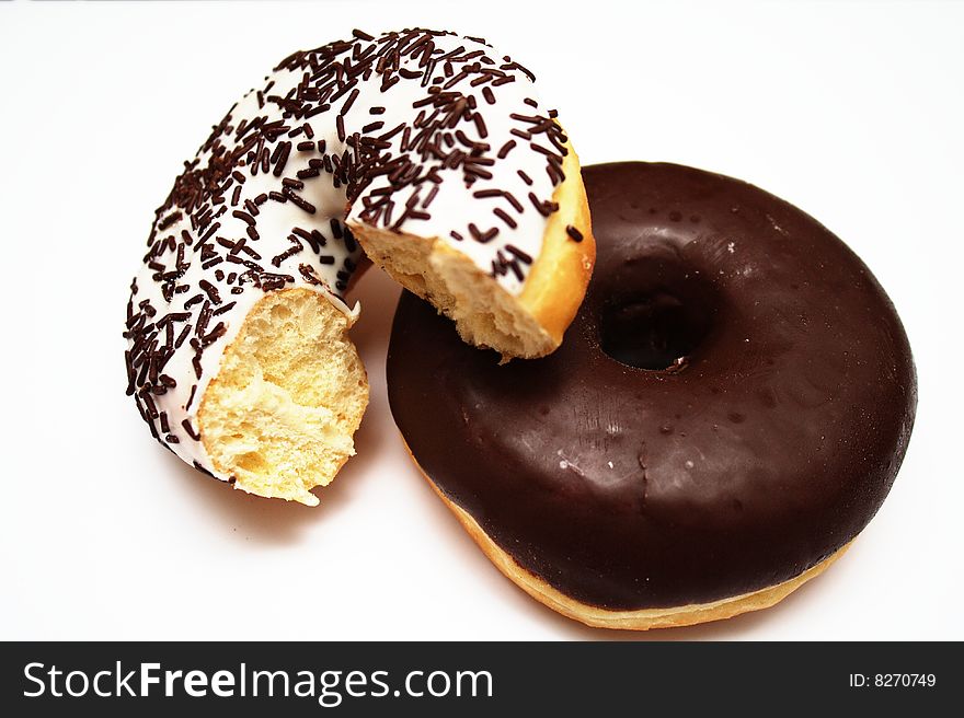 Two donuts, one with chocolate and one with icing sugar and chocolate sprinkles