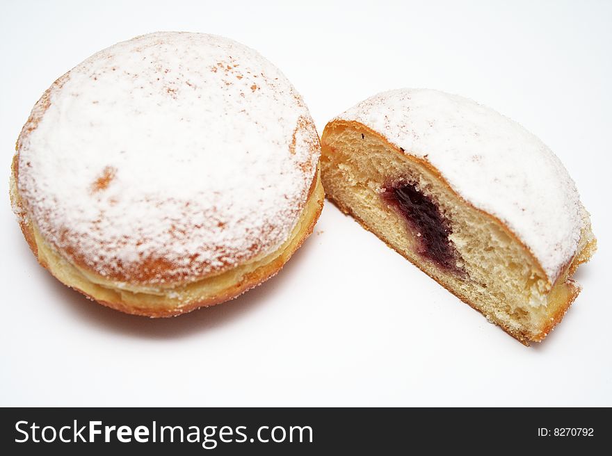 A doughnut with icing sugar on it and a nice strawberry marmalade filling inside.