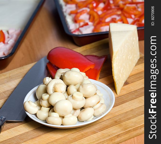 Stock photo: an image of mushrooms, paprika, cheese and knife on the table. Stock photo: an image of mushrooms, paprika, cheese and knife on the table