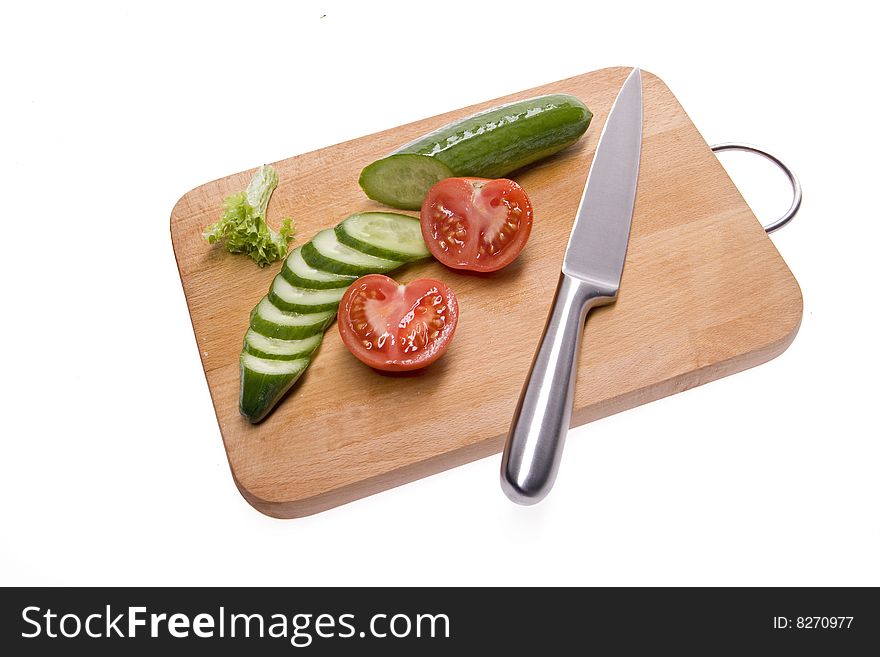 Sliced cucumber and tomato on the board. White background. Sliced cucumber and tomato on the board. White background.