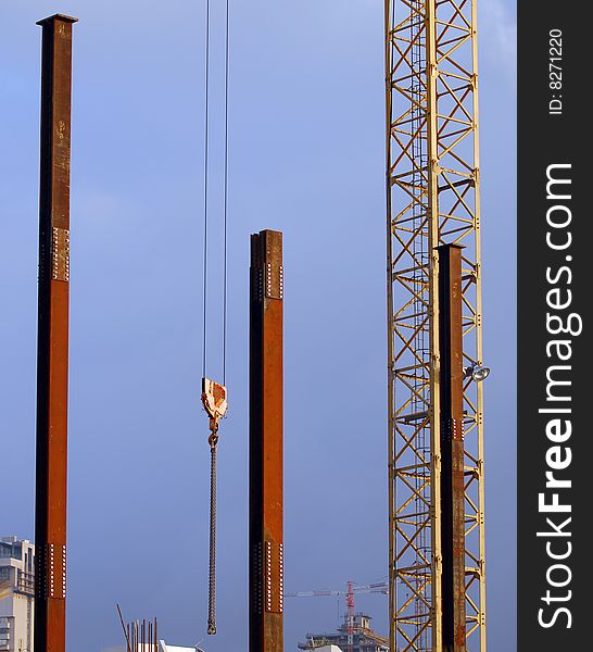 Metal poles and crane with sky as background. Metal poles and crane with sky as background
