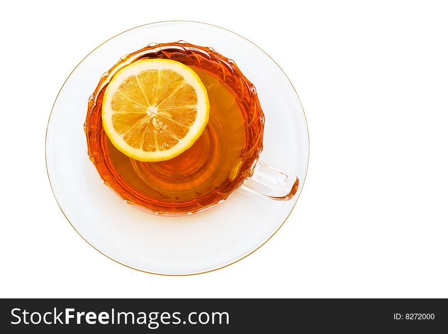 Glass cup with tea and a lemon on a white background