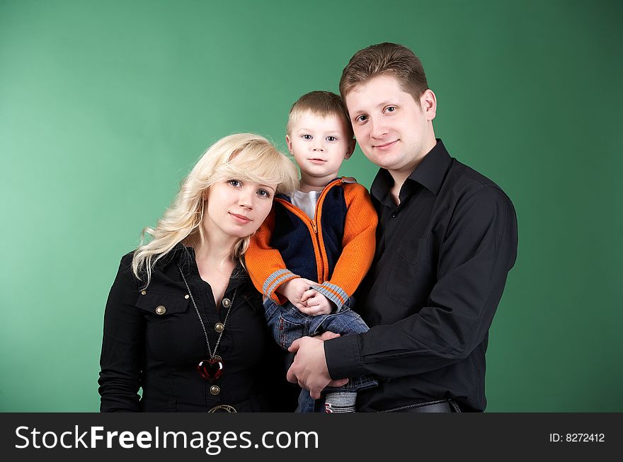 Happy family with baby on green background. Happy family with baby on green background