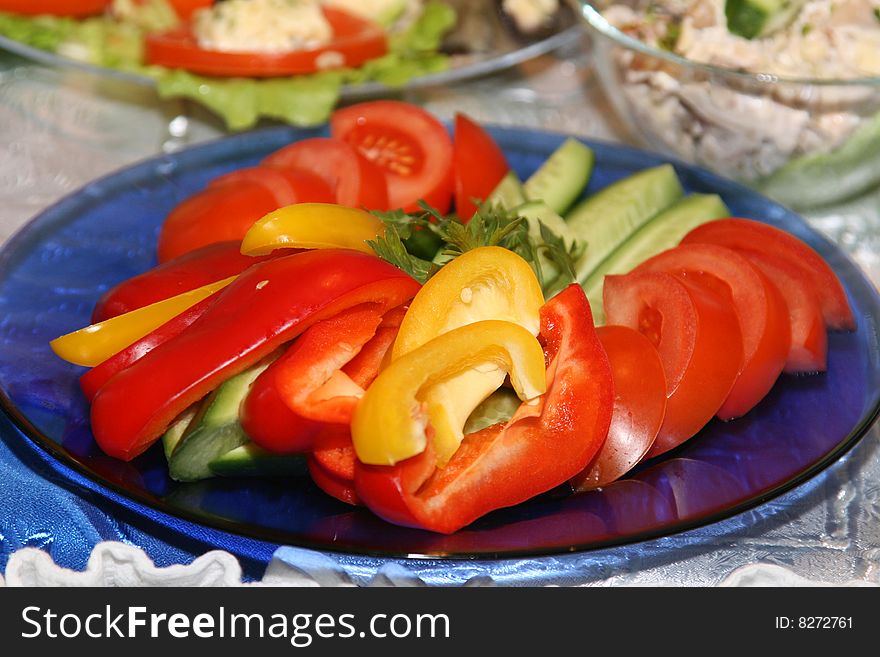 Salad on a dish from tomatoes, pepper and cucumbers