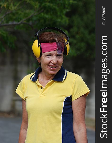 Smiling female competitor at shooting range preparing to shoot