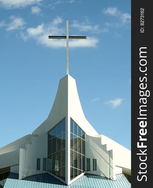 Close-up of a church cross with blue sky.