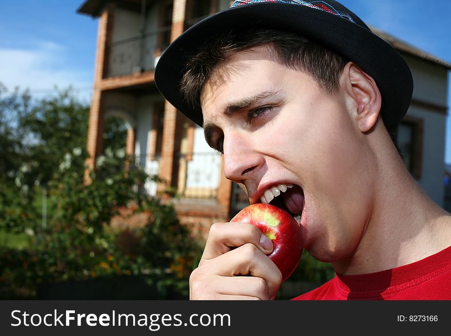 Young happy man with apple beside him new house