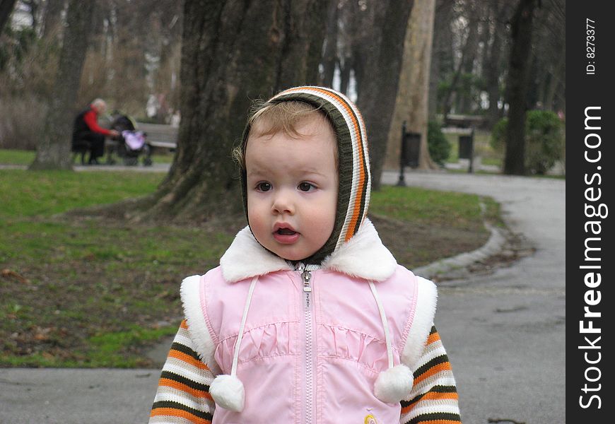 Little girl walking trough the park. Little girl walking trough the park.