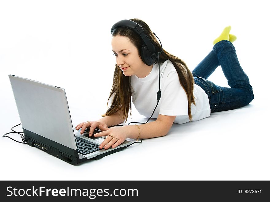 Young attractive woman wearing earphones on the floor with a laptop. Young attractive woman wearing earphones on the floor with a laptop