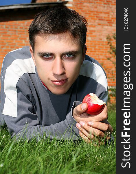 Man in green grass with apple