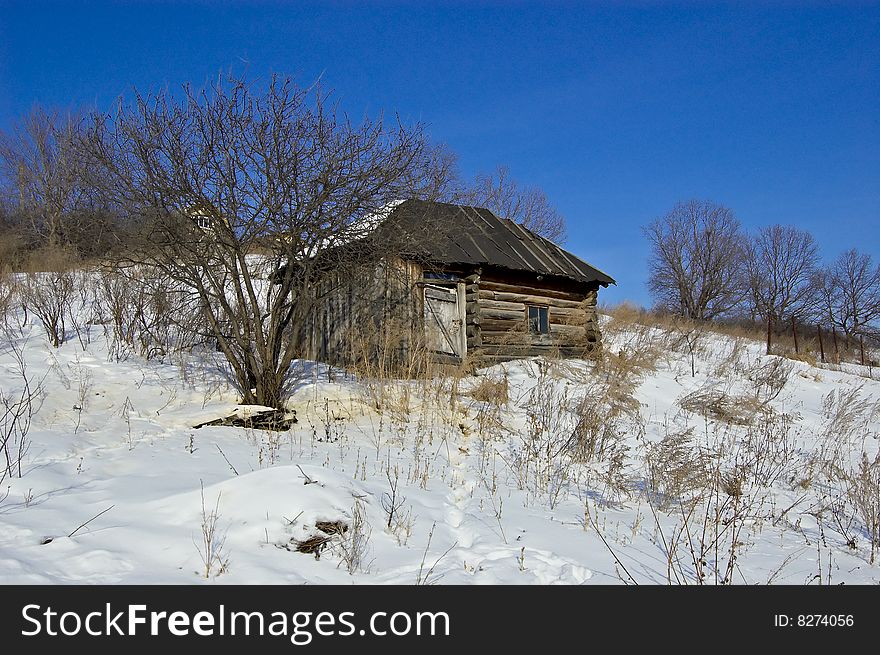 Old house amidst the snow-covered hills Russia