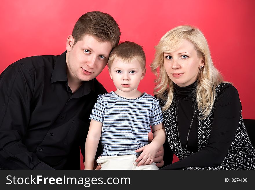 Happy family with baby on red background. Happy family with baby on red background