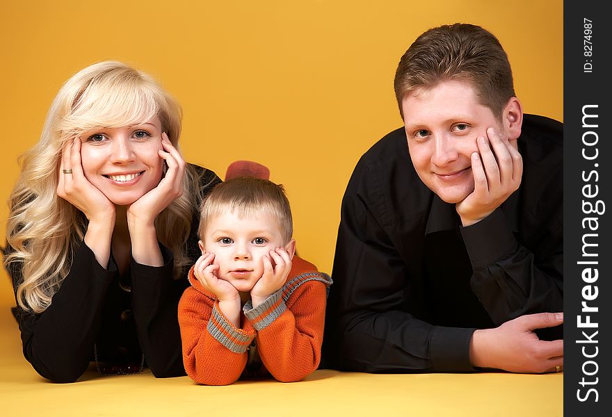 Happy family with baby on yellow background. Happy family with baby on yellow background