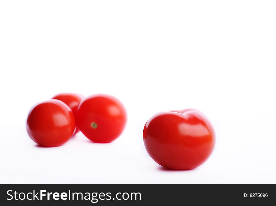 Four red tomatos one in front