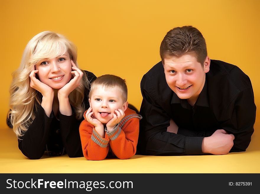 Happy family with baby on yellow background. Happy family with baby on yellow background