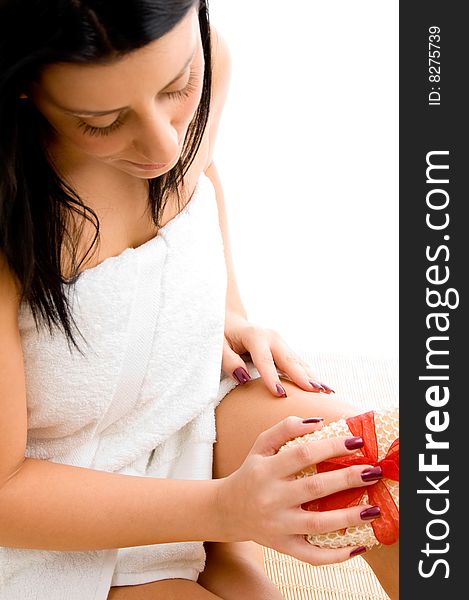 Top view of smiling young woman scrubbing her body against white background. Top view of smiling young woman scrubbing her body against white background