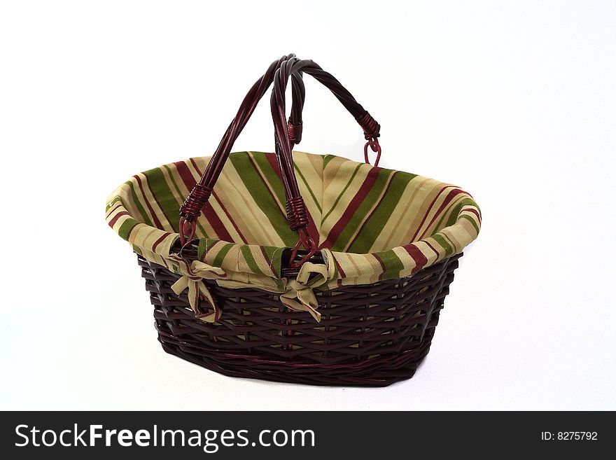 Cane basket with stripped cloth and handles isolated on white background. Cane basket with stripped cloth and handles isolated on white background